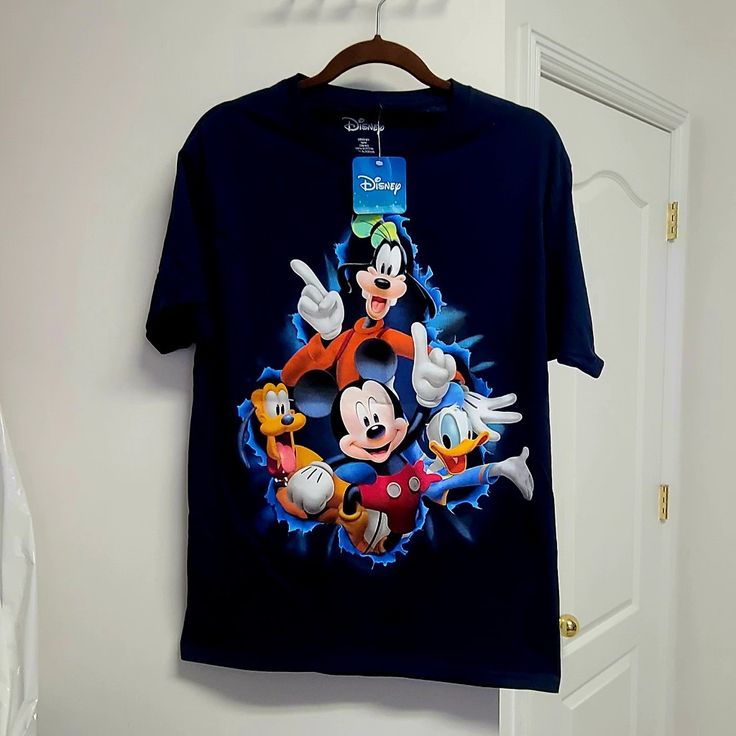 Disney T-Shirt - New With Tag. Navy Blue. Goofy And Friends On Front Side And Back Side. Size Medium. 100% Cotton. Mickey Mouse T-shirt For Disney Trips, Mickey Mouse Short Sleeve Fan Merchandise Shirt, Mickey Mouse Short Sleeve Shirt, Blue Graphic Tee With Character Print, Blue Character Print Graphic Tee, Blue Disney T-shirt For Disney Trips, Mickey Mouse Short Sleeve Top For Fans, Short Sleeve Mickey Mouse Tops For Fans, Blue Cartoon Print T-shirt For Fans