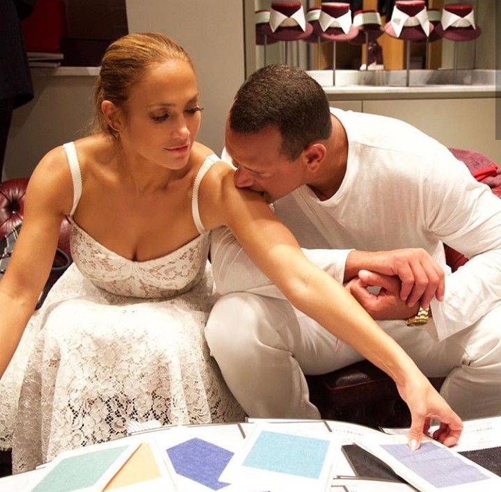 a man and woman are looking at pictures on a table with color swatches in front of them