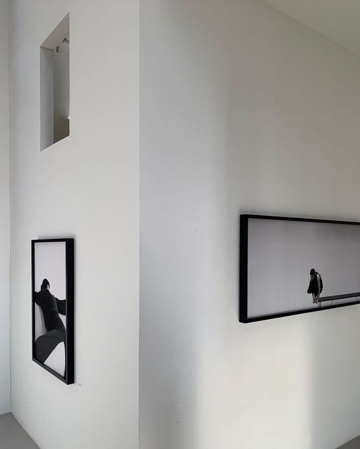 two black and white pictures hanging on the side of a wall next to each other