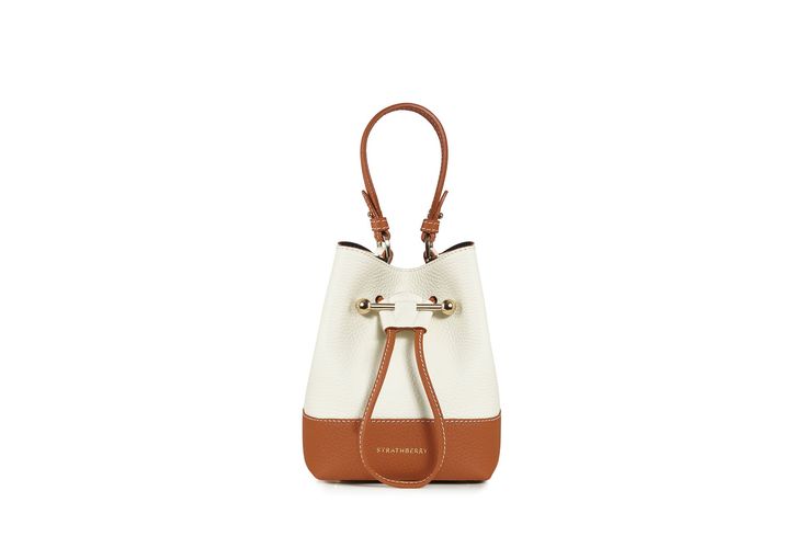 Handcrafted to a soft structure from buttery soft pebbled finish leather, the Lana Osette features an elegant drawstring closure completed with the Strathberry signature bar. In a new take on a classic bucket bag silhouette, this versatile and compact daywear bag features both a top handle and a longer strap, allowing it to be carried crossbody or in the hand.This style is available exclusively for Spring/Summer 21. Luxury Cognac Bucket Bag With Adjustable Strap, Chic Bucket Bag With Leather Handles, Modern Cognac Shoulder Bucket Bag, Modern Cognac Bucket Bag With Removable Pouch, Timeless Bucket Bag With Detachable Strap, Timeless Brown Bucket Bag With Detachable Strap, Chic Everyday Bucket Bag, Elegant Cognac Hobo Bag For Everyday, Chic Everyday Cognac Bag