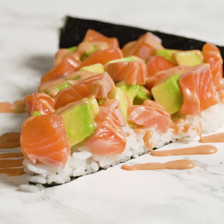 sushi with avocado, salmon and cucumber on top