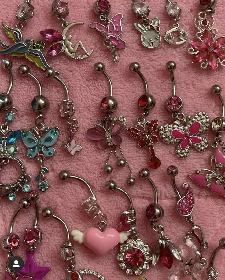 many different types of charms on a pink blanket