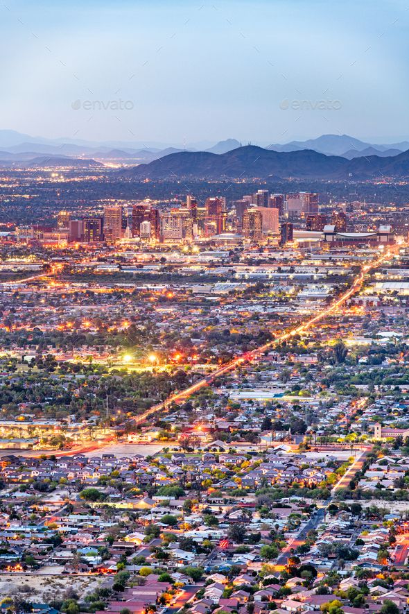 an aerial view of a city at night with mountains in the background - stock photo - images