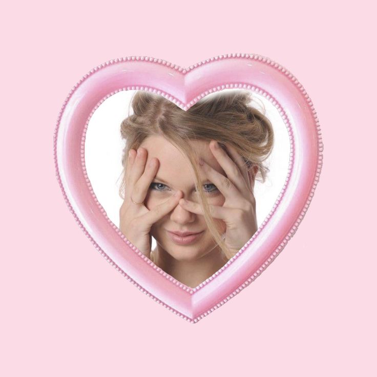 a woman holding her hands to her face in front of a pink heart shaped frame