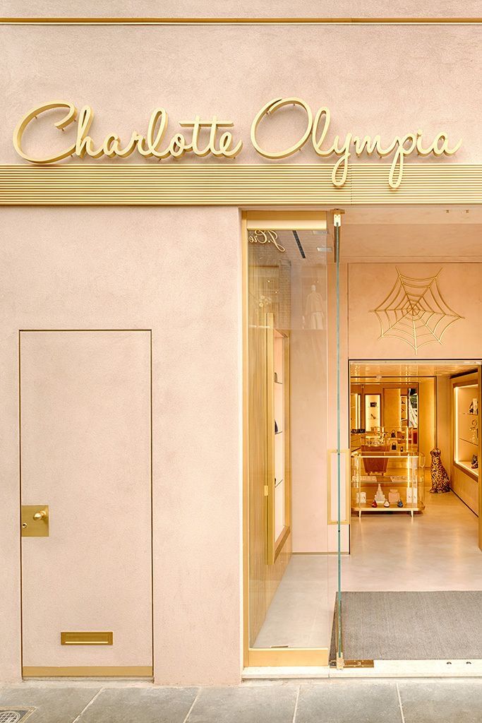 the entrance to charlotte orange is lit up in pink and gold with an open door