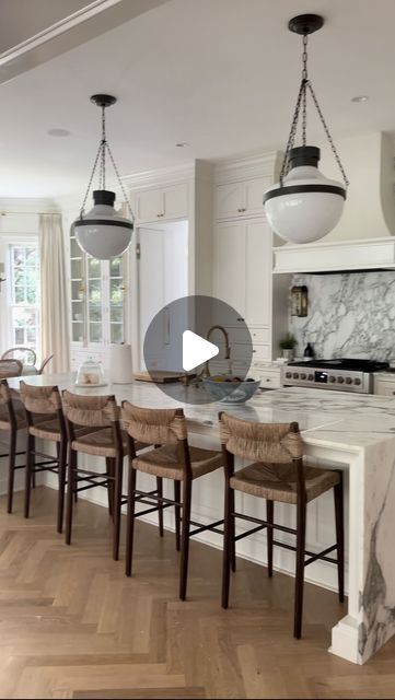 a large kitchen with marble counter tops and wooden chairs