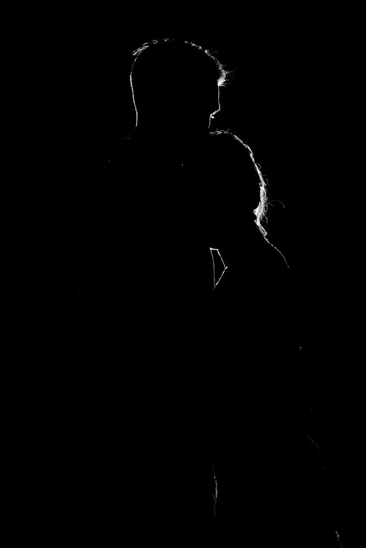 a man standing in the dark with his head down