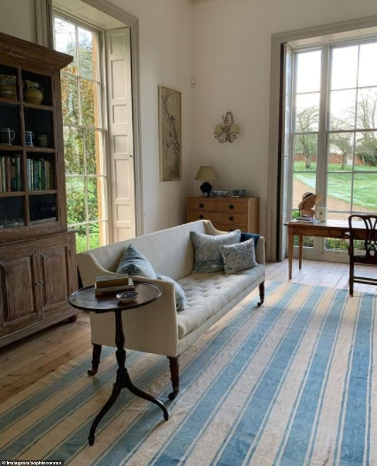 a living room filled with furniture next to a large glass door leading to a lush green field