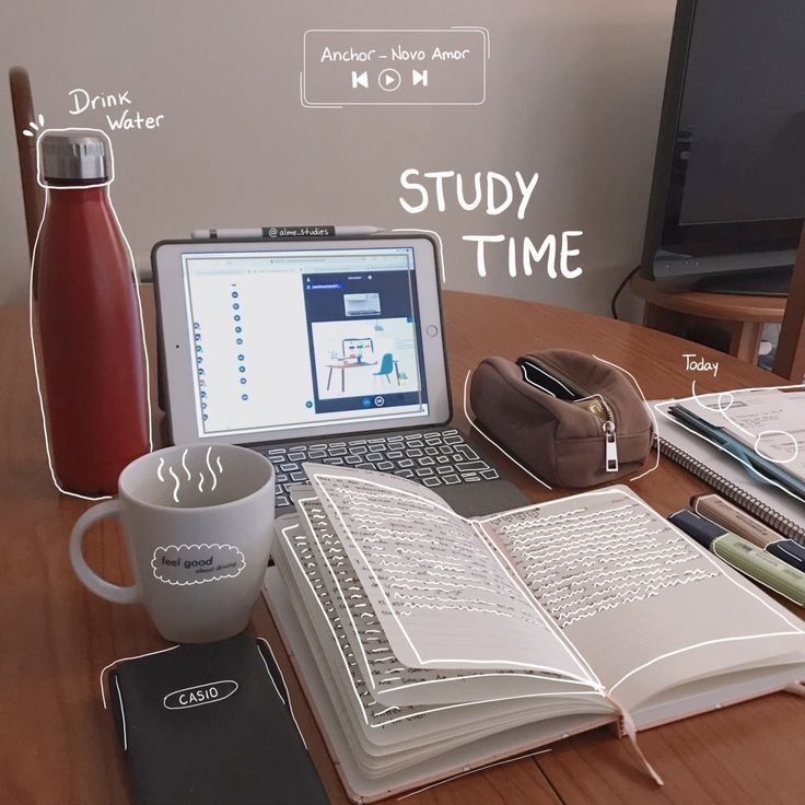 an open book sitting on top of a wooden table next to a laptop and coffee cup