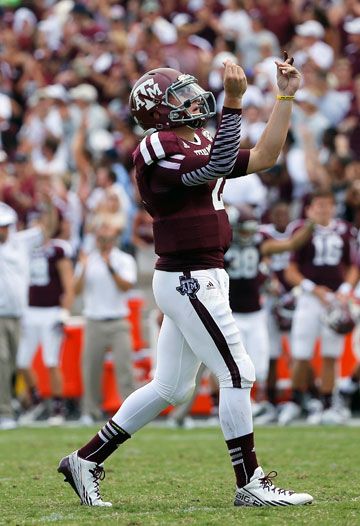 a football player throwing a ball in front of a large group of people on the field