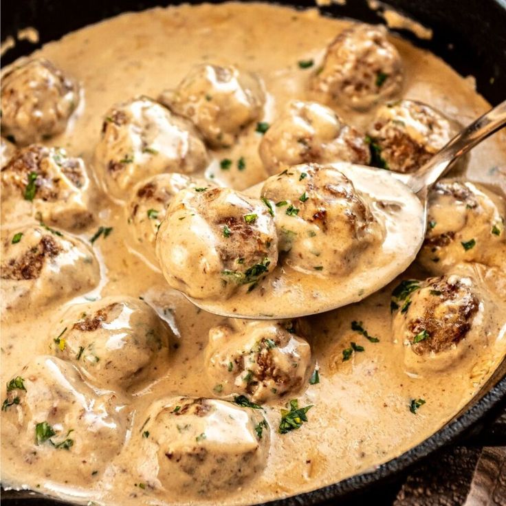 a skillet filled with meatballs and gravy