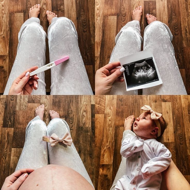 a baby laying on the floor next to an adult's feet and holding a toothbrush