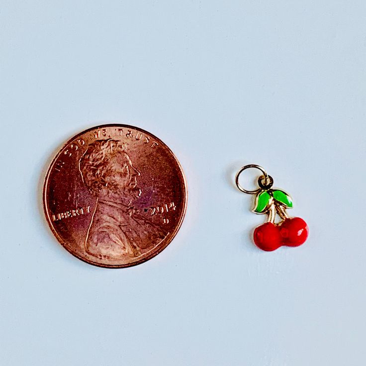 "A beautiful 14K solid yellow gold Red Cherry puffy charm / pendant with hand painted and baked enamel. It has a soldered ring to attach to a bracelet or a necklace. The small pendant measures 10mm (0.39\") tall with bail and without the soldered ring and 7.3mm (0.29\") wide. It can be used as a necklace pendant or a bracelet charm and would make a perfect gift. The pendant can be paired with a shiny 14K Yellow Gold 1.2mm cable link chain in either 16\" or 18\" length or with a 16\" 14K gold-pla Nickel Free Enamel Jewelry, Dainty Handmade Enamel Jewelry, Handmade Dainty Enamel Jewelry, Small Red Jewelry Perfect For Gifting, Small Red Jewelry For Gift, Round Vintage Charms For Gifts, Dainty Tiny Red Jewelry, Dainty Enamel Nickel-free Jewelry, Tiny 14k Yellow Gold Charm Necklaces