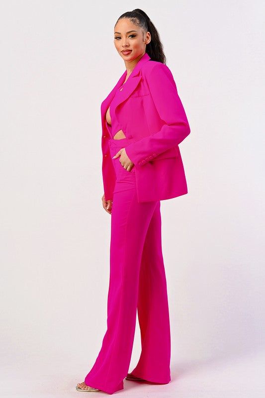 Make a statement in this sleek jumpsuit & blazer set. The hot pink color adds a bold touch to this two piece suit, perfect for a night out or special occasion. The high quality imported fabrics ensure a comfortable and flattering fit. The long sleeve design features eye-catching cutout details, adding a touch of sexiness to the overall look. Available in black or pink, this chic ensemble will turn heads and make you stand out from the crowd. The fabric contents of this set are made of polyester Spring Night Out Suit With Notch Lapel, Spring Notch Lapel Suit For Night Out, Spring Notch Lapel Suits For Night Out, Spring Party Pantsuit With Notch Lapel, Chic Notch Lapel Pantsuit For Night Out, Spring Party Suit In Solid Color, Pink Fitted Pantsuit For Night Out, Chic Suits For Night Out In Spring, Pink Suits For Spring Evening