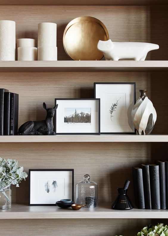 the shelves are filled with books, vases and pictures