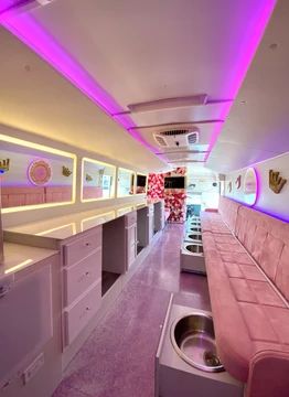 the interior of an airplane with purple lighting and pink couches on both sides of the aisle