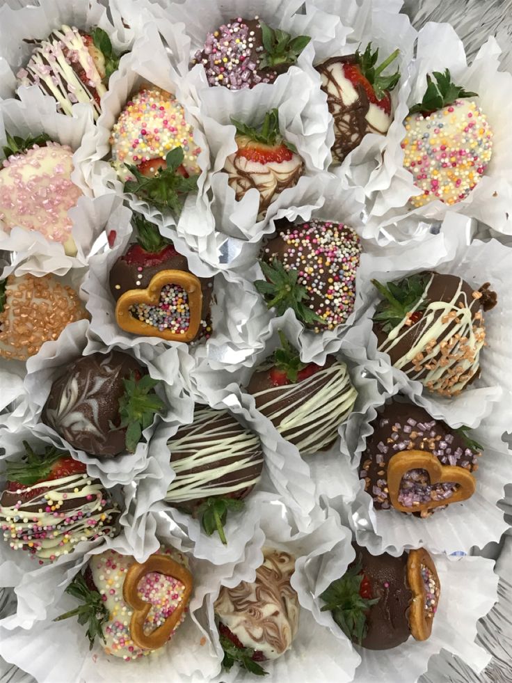 chocolate covered strawberries are arranged on white paper