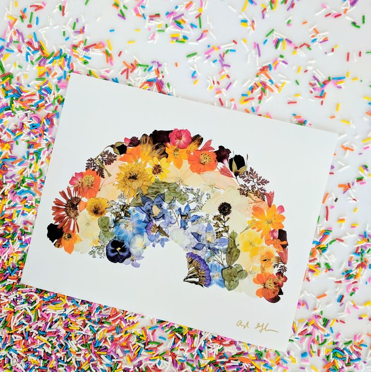 a card with an image of a bear surrounded by flowers and sprinkles