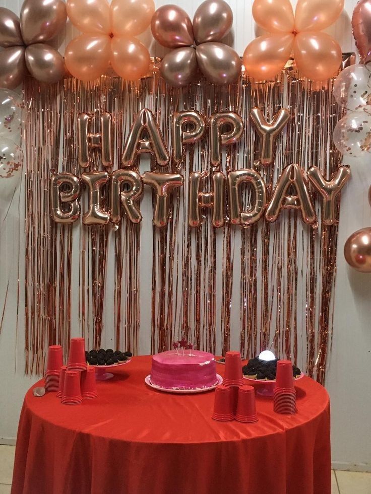 a red table topped with a cake and balloons