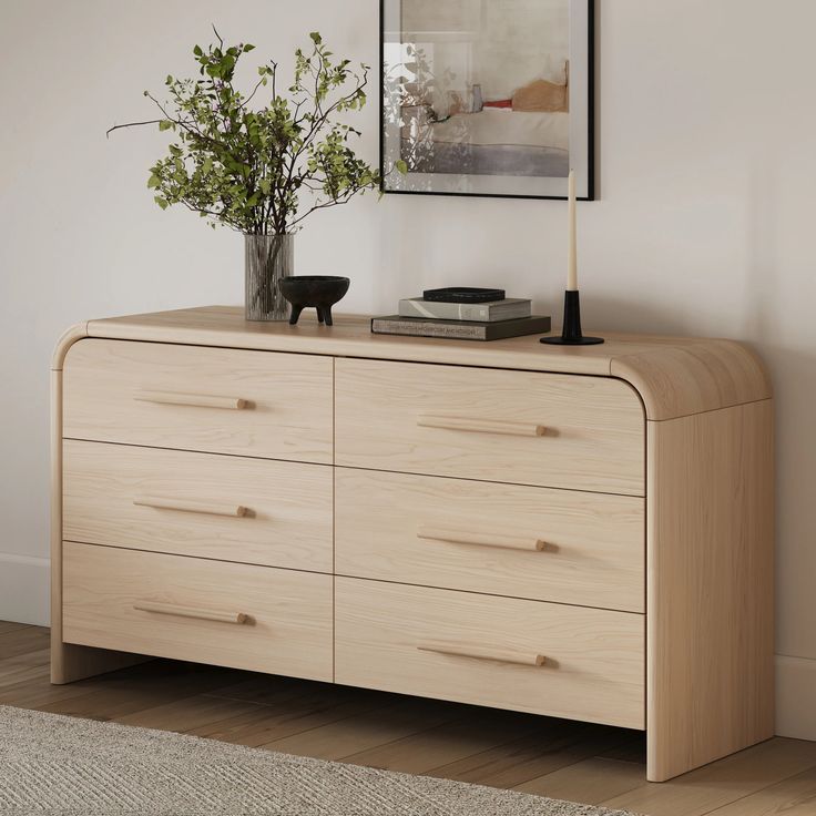 a wooden dresser with two vases on top of it and a plant in the middle