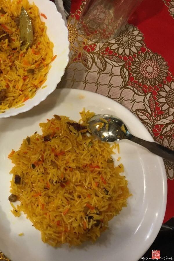 two plates filled with rice on top of a table next to silverware and utensils