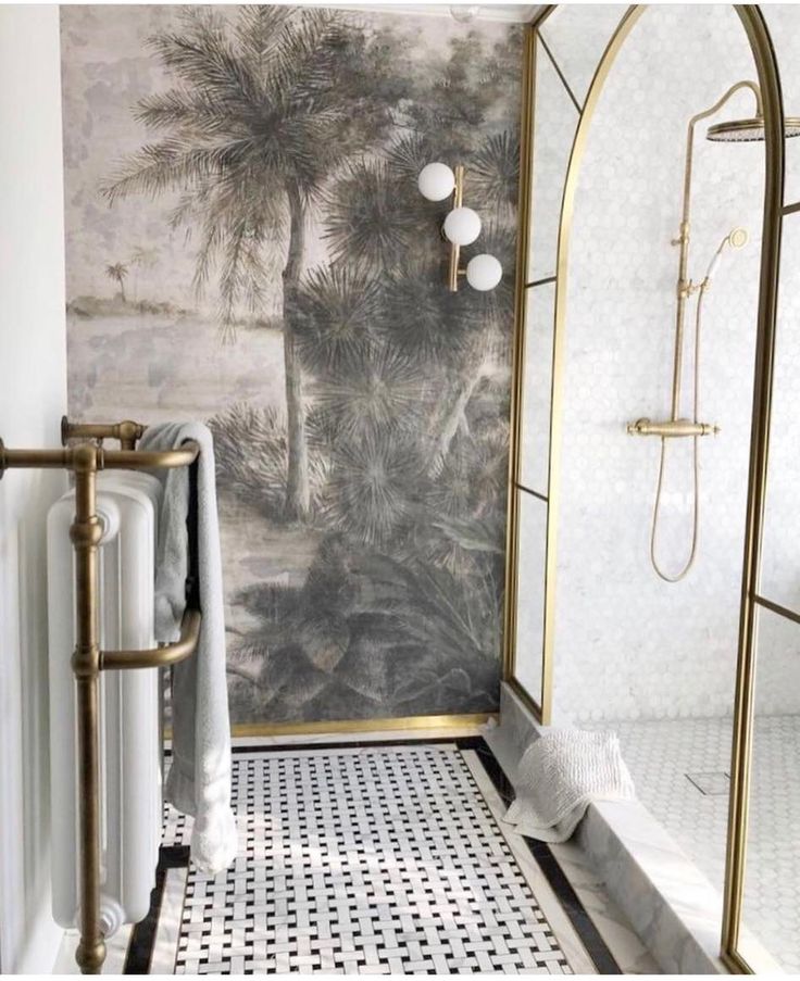 a white and gold bathroom with palm trees on the wall, black and white tile