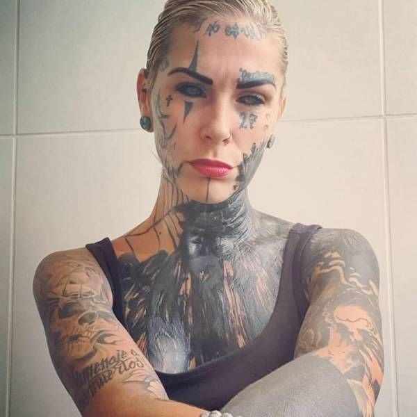 a woman with tattoos on her face and arm