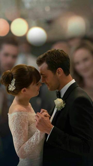 a bride and groom standing next to each other in front of a group of people