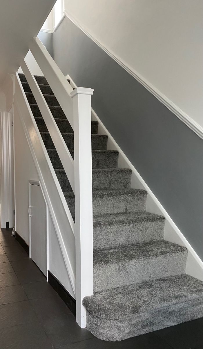 a staircase with carpeted steps leading up to the second floor