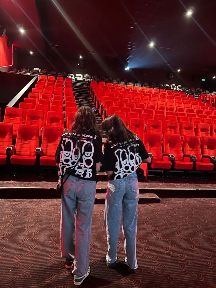 two people standing in front of an empty auditorium