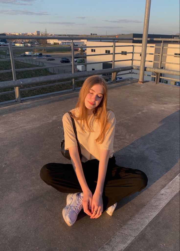 a woman sitting on the ground with her legs crossed