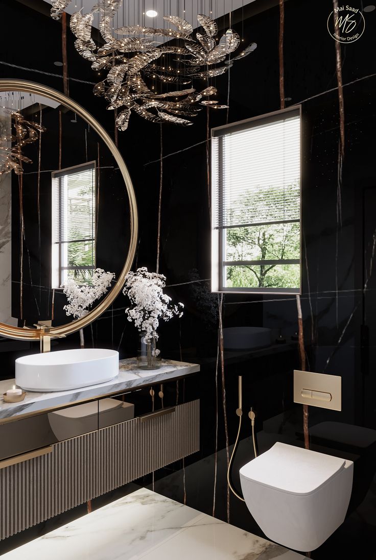 a black and white bathroom with a round mirror hanging from the ceiling over the sink