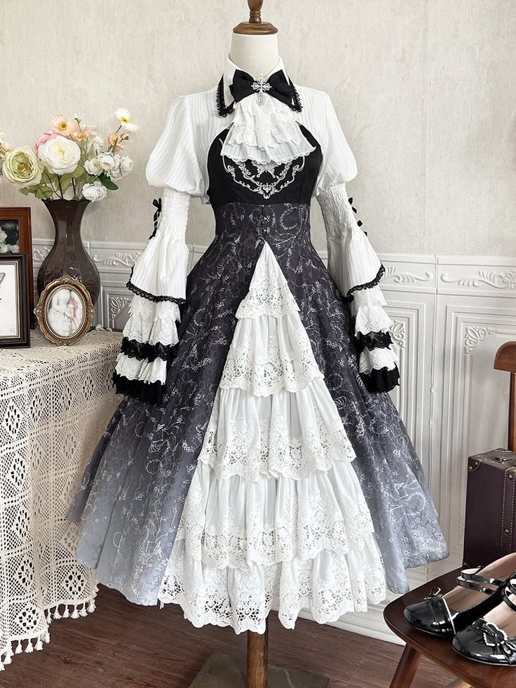 This enchanting piece features a hauntingly beautiful ombre effect that transitions from deep black to mystical shades, adorned with intricate skeleton and vine prints. The dress is complemented by a matching bell sleeves bolero, adding a touch of vintage sophistication and dramatic flair. Perfect for gothic Lolita enthusiasts.  Dress   	 		 			Size 			S 			M 			L 		 		 			Full Length 			106 			108 			110 		 		 			Bust 			86 			90 			94 		 		 			Waist 			69 			73 			77 		 	     Top   	 		 			Siz Black Dress With White Accents, Black And White Victorian Dress, Victorian Dress Design, Nobel Dresses, Egl Fashion Gothic, Witch Dress Drawing, Dark Academia Prom Dress, Dress Shading, Surreal Clothing