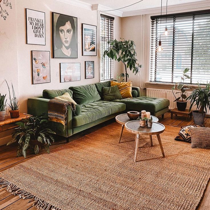 a living room with green couches and pictures on the wall above it's coffee table