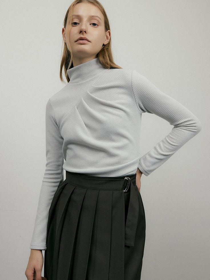 This is a unique t-shirt that creates a three-dimensional silhouette with diagonal cuts and pin tuck details. The sides are also made with pin tuck shirring to create a slim and feminine silhouette. Elastic and comfortable to wearHigh neck keeps you warmAn item that can also be used as innerwear Fitted Tops With Folds For Spring, Spring Fitted Tops With Folds, Trendy Fitted Pleated Top, Chic Tops With Folds For Workwear, Chic Pleated Stretch Top, Athleisure Crew Neck T-shirt With Ribbed Cuffs, Ribbed Cuffs Crew Neck T-shirt, Casual High Neck Stretch T-shirt, White Crew Neck T-shirt With Ribbed Cuffs