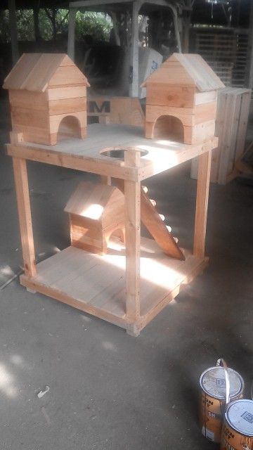 two wooden bird houses sitting next to each other on top of a cement floor in front of a building