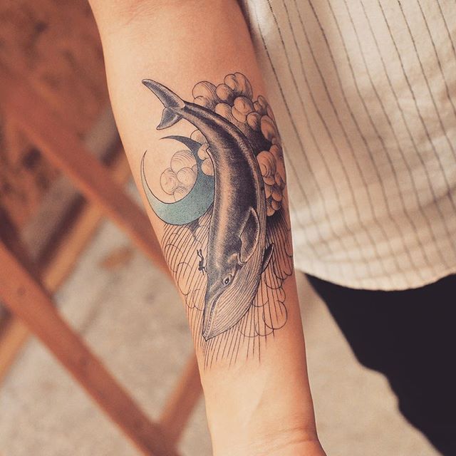 a person with a dolphin tattoo on their arm