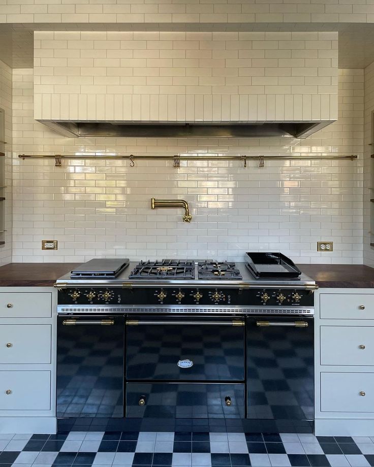 a stove top oven sitting inside of a kitchen next to a wall mounted range hood