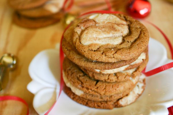 a stack of cookies sitting on top of a white plate next to a red ribbon