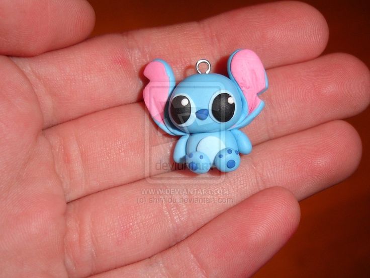 small blue and pink elephant charm sitting on someone's hand with it's eyes wide open