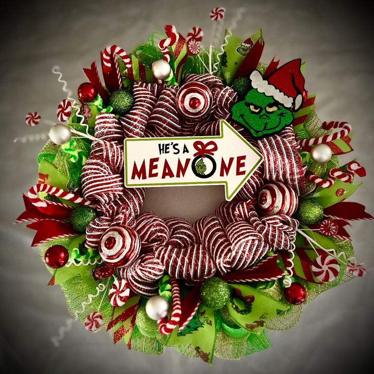 a christmas wreath decorated with candy canes and grino's head on it