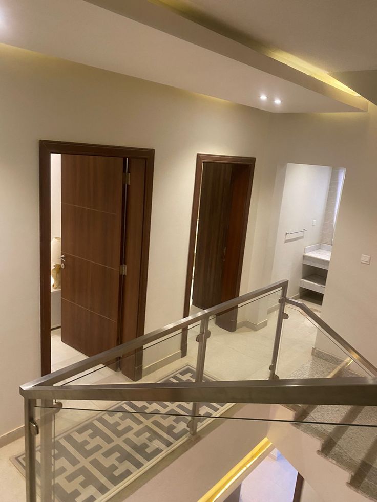 an empty room with wooden doors and metal handrails