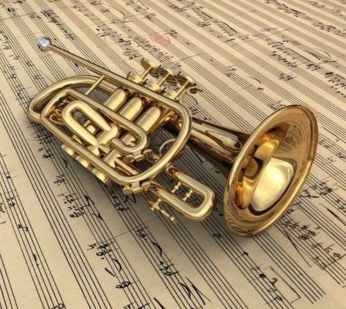 an old brass french horn laying on sheet music