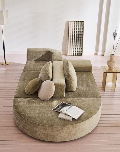 a living room with a large round couch on the floor and a magazine laying on top of it