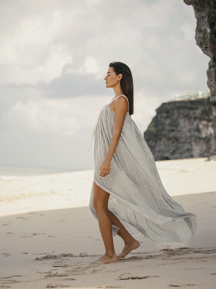 The soft and romantic Breeze Beach Dress Black Stripes is inspired by the summer breeze. This beach cover up features braided straps and can be worn in many different ways to have the desired boho-chic look. Have a fancy drink or lounge in this beach cover up. It is a must-have vacation dress for this summer. - 100% Turkish cotton- Adjustable straps- One size fits most How to wear it Pair the bikini and bare feet, you will be ready for a cocktail party on tropical beach. Fitting guidelines Lengt Beachwear Dresses With Tie Back For Beach, Beachwear Dresses With Tie-back For Beach, Chic Tie-back Maxi Dress For The Beach, Flowy Tie Back Dress For Beach, Flowy Tie-back Beach Dress, Beachy Flowy Maxi Dress For Poolside, Summer Tie-back Maxi Dress For Beach Season, Chic Beach Sundress With Tie Back, Beachwear Dresses With Tie Back For Beach Season