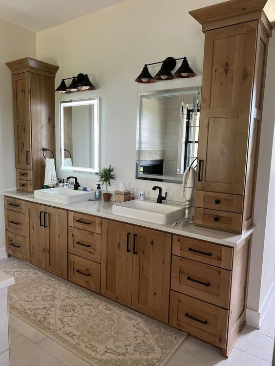 a bathroom with double sinks and wooden cabinets