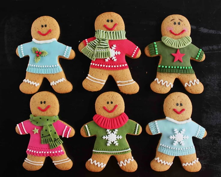 six decorated gingerbread men and women on a black background