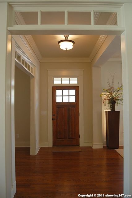 an open door is shown in the middle of a room with wood floors and white trim