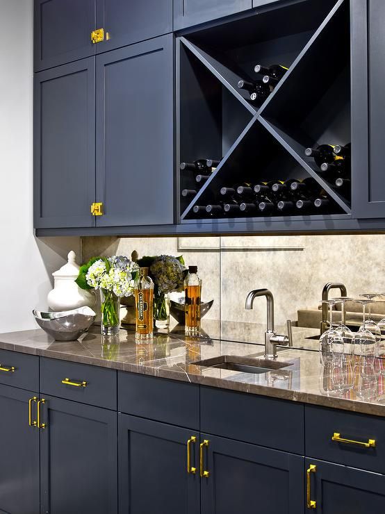 a wine rack in the middle of a kitchen with marble counter tops and blue cabinets