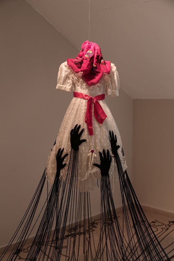 a dress made out of sticks with hands on it